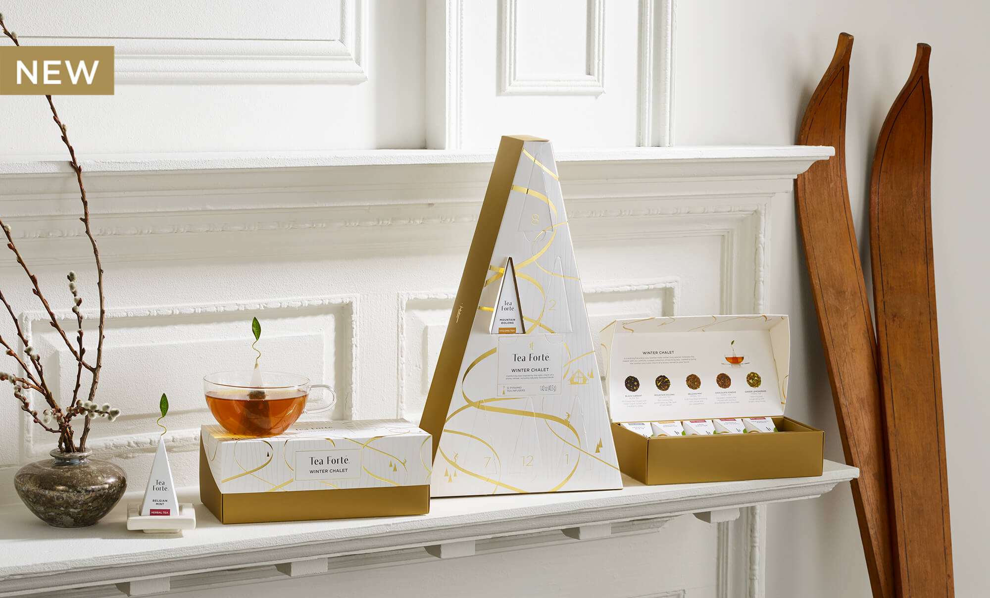 Winter Chalet Collection boxes, opened and closed, on a white shelve with glass teacup and antique wooden skis