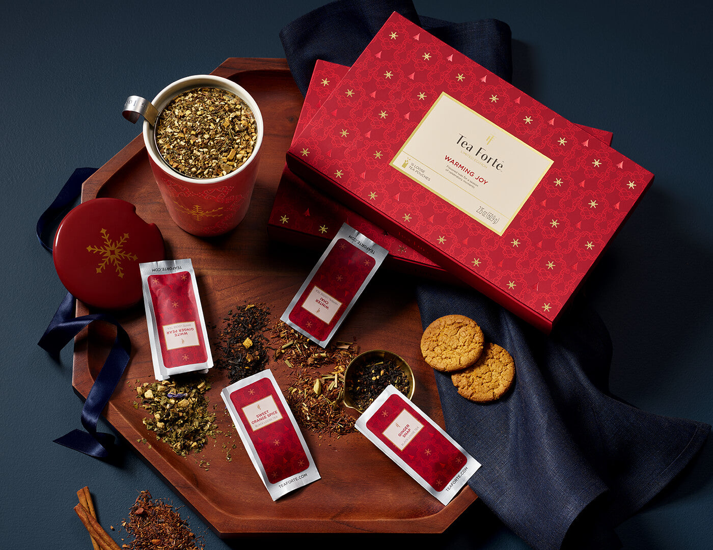 Single Steeps Sampler Warming Joy, closed with KATI Steeping Cup and loose tea pouches on a wooden tray