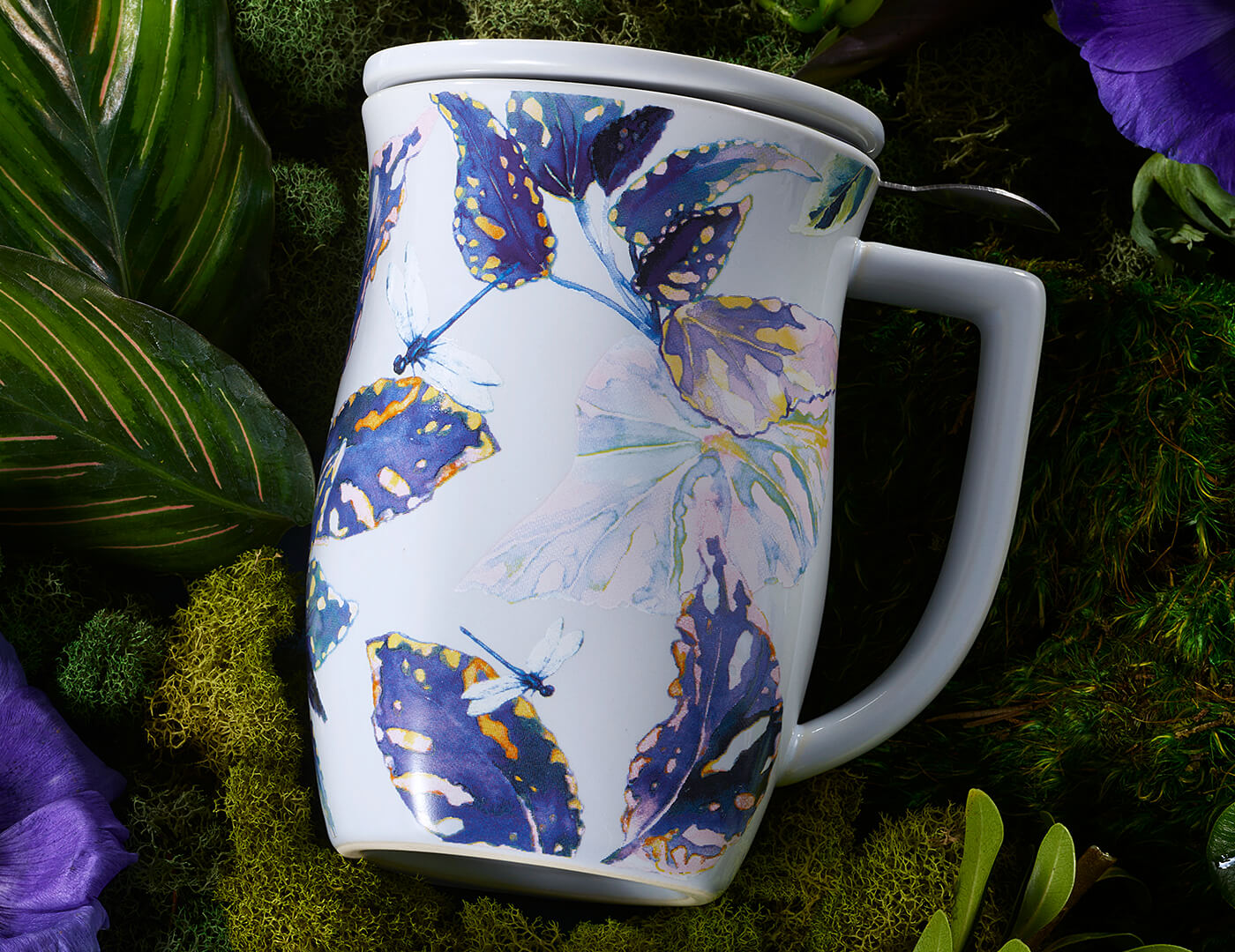 Demoiselle Fiore Steeping Cup, closed, with lid on, laying amongst moss and plants