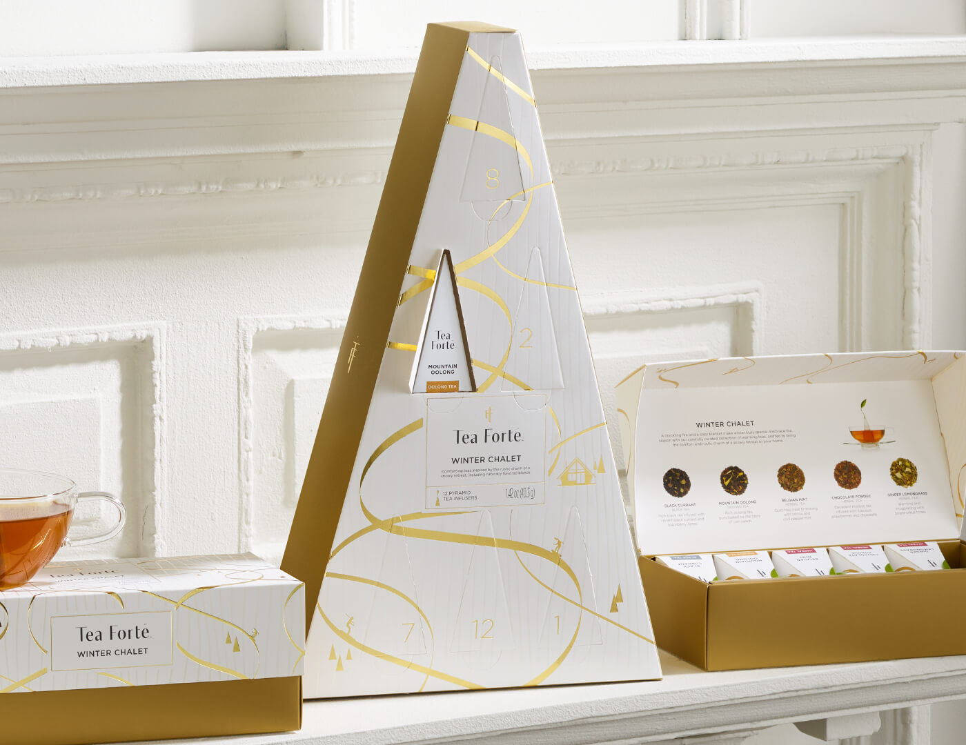 Winter Chalet Advent, with one door open, on a white shelf with other Winter Chalet products